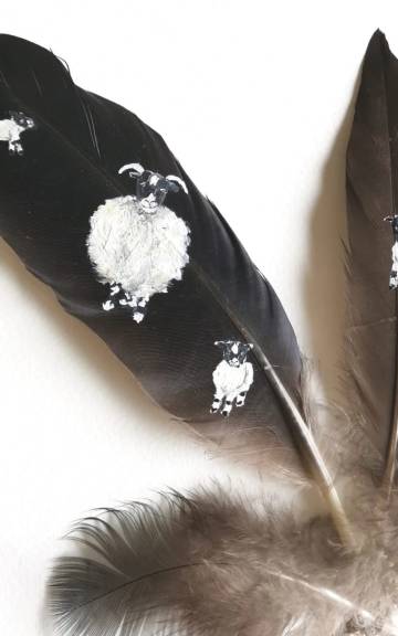 Sheep and lambs painted on raven and duck feathers